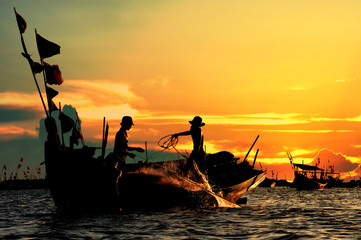 silhouette of fishermen in sunset