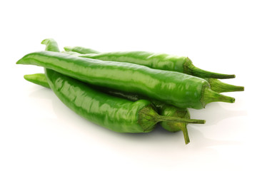 bunch of fresh  green chili peppers on a white background