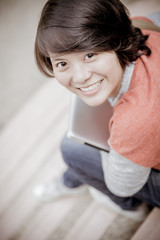 Young woman using laptop on steps outdoors