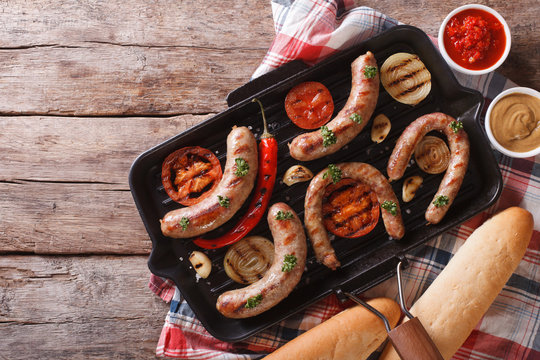 sausages with vegetables in a pan grill. horizontal top view