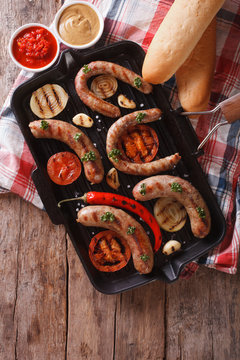 sausages with vegetables in a pan grill.  Vertical top view