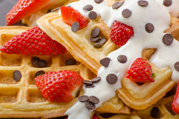 Homemade waffles with maple syrup and strawberries