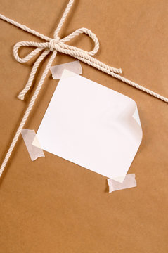 Brown paper package parcel background tied with string or rope and blank message or address label photo