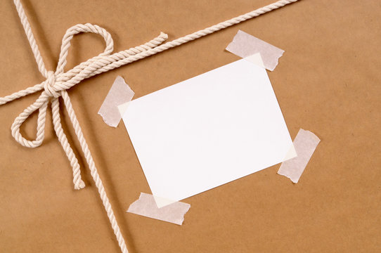 Brown paper package parcel background tied with string or rope and blank message or address label photo