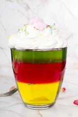 Colorful jelly with whipped cream and candy topping