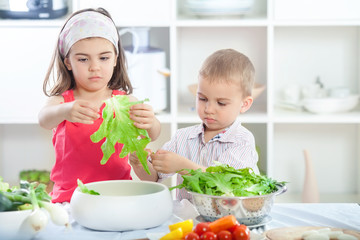 Cute little brother and sister preparing healthy vegan meal