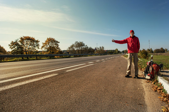 Young Man Hitchhiking on a Road
