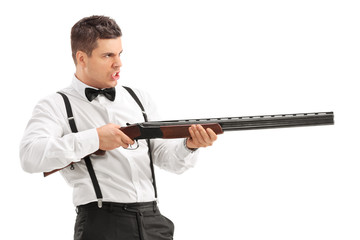 Angry young man shooting with a shotgun