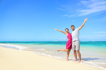 Freedom on beach vacation - happy carefree couple