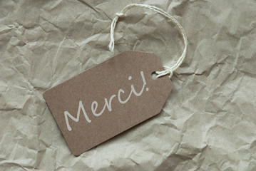 Beige Label With French Merci Means Thank You Paper Background
