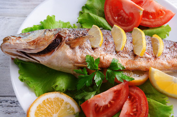 Tasty baked fish on table close-up