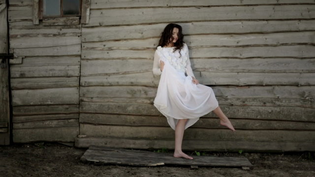 Slender girl near a wooden house