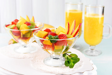 Fruit salad with mint and orange juice in glassware