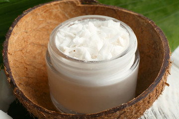 Fresh coconut oil in glass bottle and green leaf