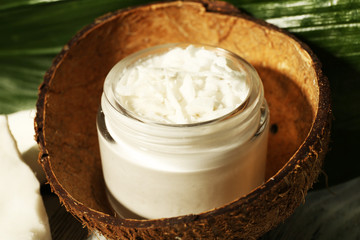 Fresh coconut oil in glass bottle and green leaf