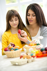 Mother and daughter painting eggs
