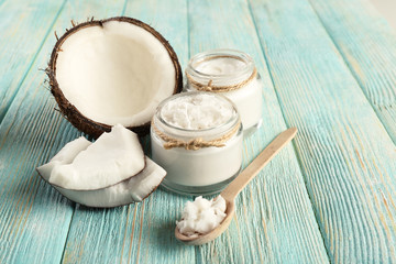 Fresh coconut oil in glassware and wooden spoon