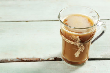 Glass cup of cocoa on color wooden planks background