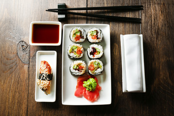 Vegetarian sushi rolls on plate, on wooden background