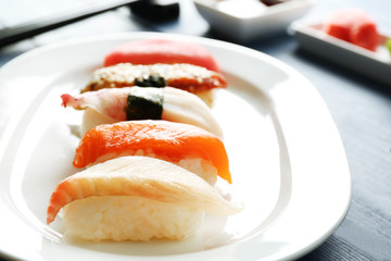 Sushi on plate on wooden table background
