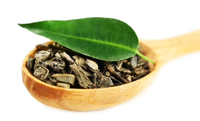 Cuillère en bois avec du thé vert avec des feuilles isolées sur blanc