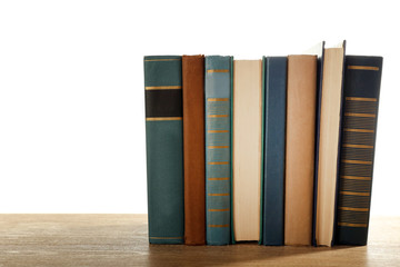 Old books on wooden table isolated on white