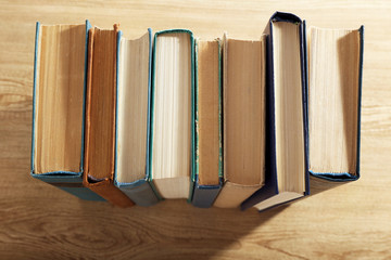 Old books on wooden table, top view