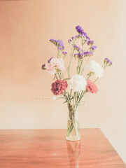 Beautiful summer flowers in vases on wooden background