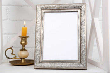 Photo frame on shelf with candlestick on brick wall background