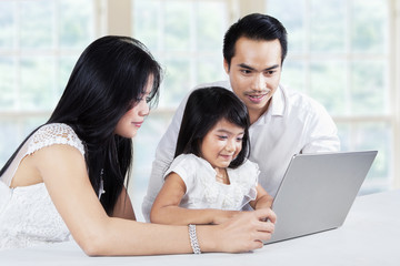 Family browsing internet with laptop on table
