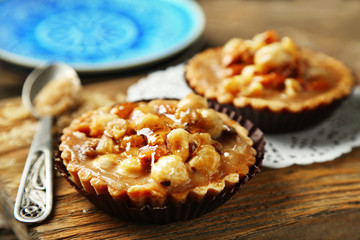 Mini cakes with nuts on wooden background