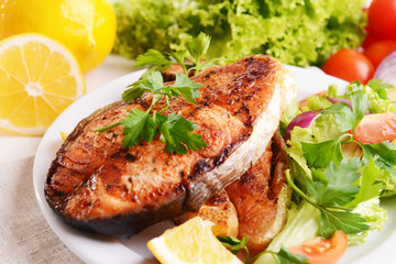 Tasty baked fish on plate close-up