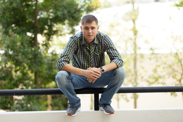 Obraz premium Man squatting on a ledge