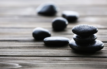 Spa stones with water drops on wooden background