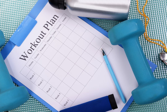 Workout plan and sports equipment top view close-up