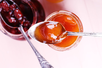 Jars of tasty jam on wooden background