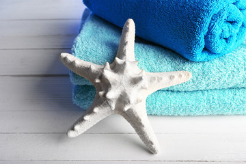 Terry towels with starfish on wooden table background