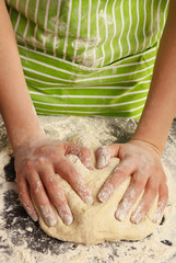 Making dough by female hands on wooden table background