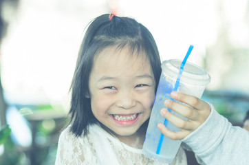 Portrait of Asian girl and cool drink on face.