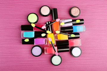 Naklejka premium Set of colorful cosmetics on pink wooden table background