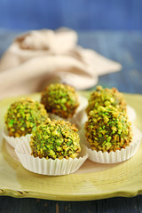 Tasty homemade pistachio candies on wooden table