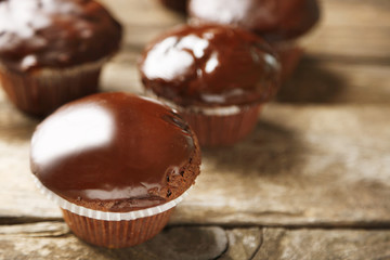 Tasty homemade chocolate muffins on wooden table