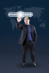 Male worker pressing start button