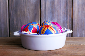Easter eggs in bowl on wooden background