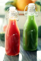 Bottles of juice with fruits and vegetables  in crate