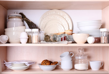 Kitchen utensils and tableware on shelves