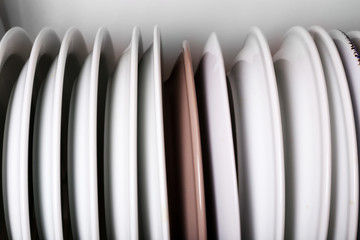 Fototapeta premium Clean plates drying on metal dish rack close up