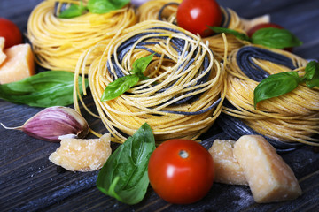 Raw pasta with cheese and vegetables on table close up