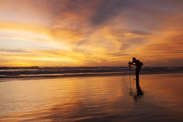 Fototapeta premium Silhouette of photographer on the beach