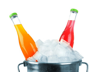 Bottles of tasty drink in metal bucket with ice isolated